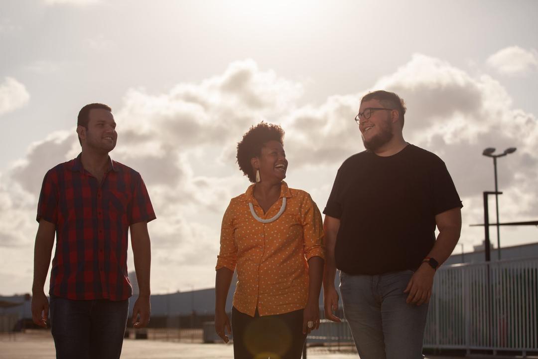 Três pessoas reunidas ao ar livre