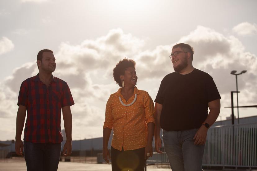 Três pessoas reunidas ao ar livre