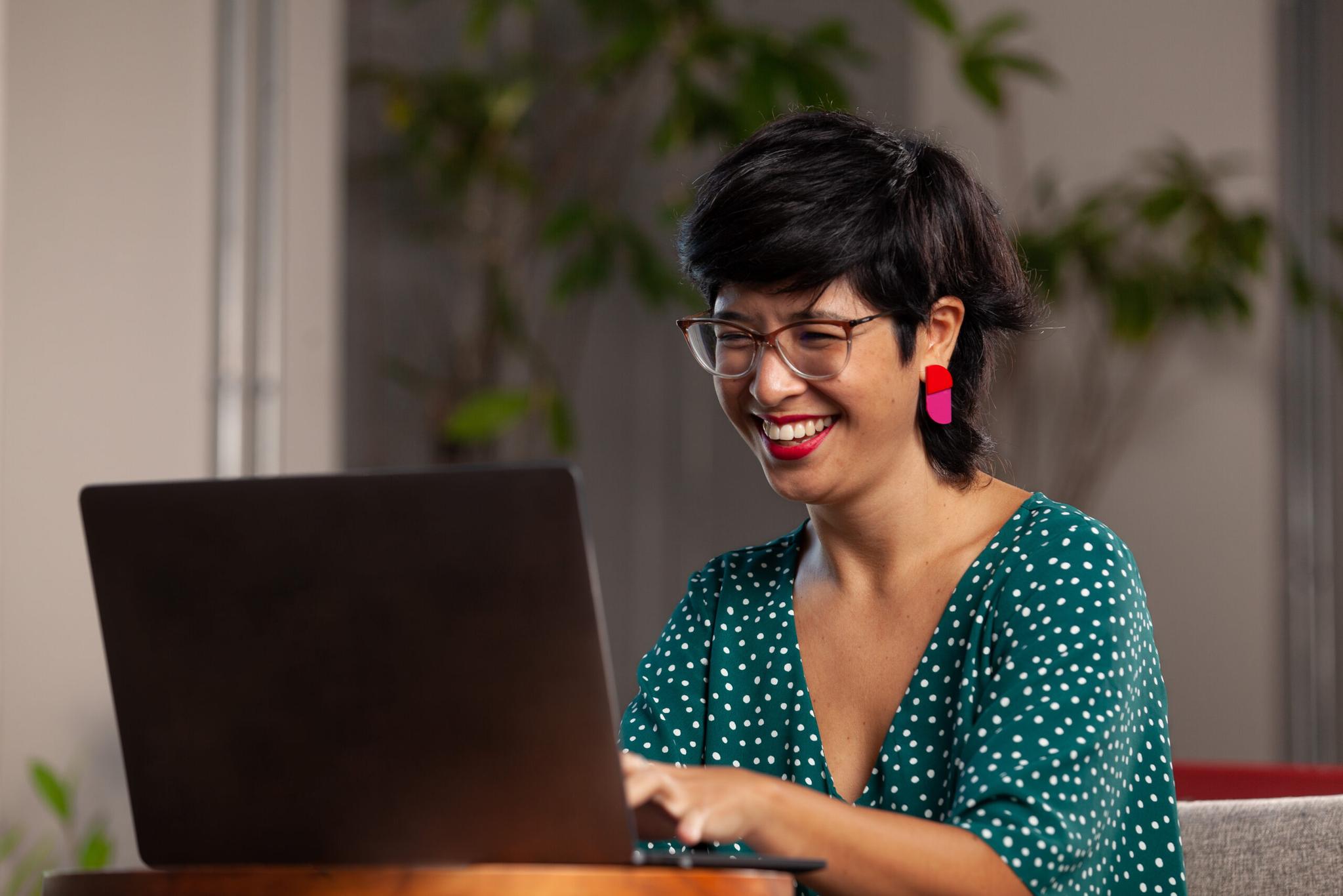 Mulher sorrindo olhando para o notebook