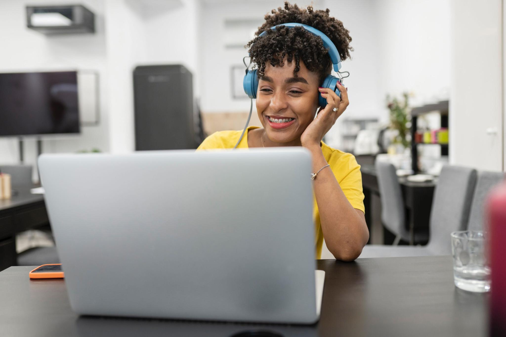 Uma mulher com fone de ouvido olhando para o notebook