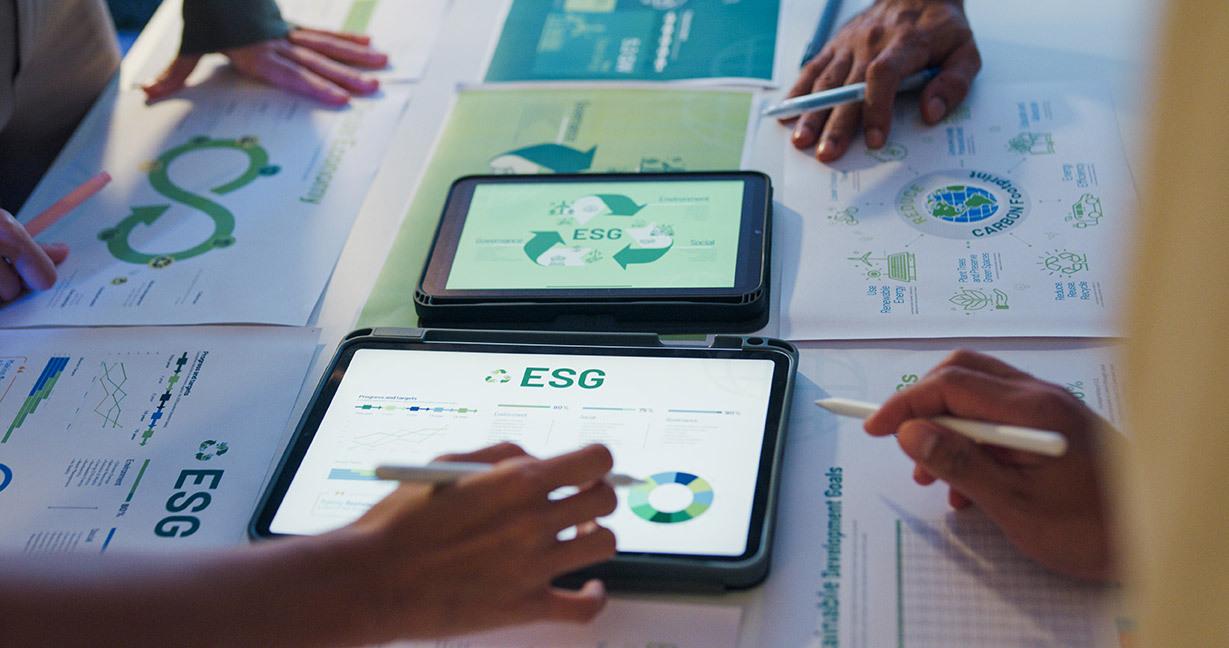 Pessoas analisando resultado em folhas e tablets sobre ecologia