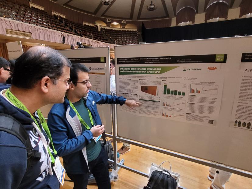 Dois homens examinam um pôster de conferência sobre simulação de geomecânica com a CPU NVIDIA Grace.
