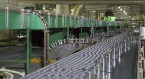 Linha de produção automatizada em fábrica, mostrando processo industrial e automação de manufatura.