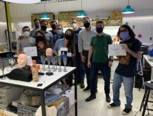 Equipe de ensino tecnológico em laboratório, com projetos de impressão 3D e prototipagem.
