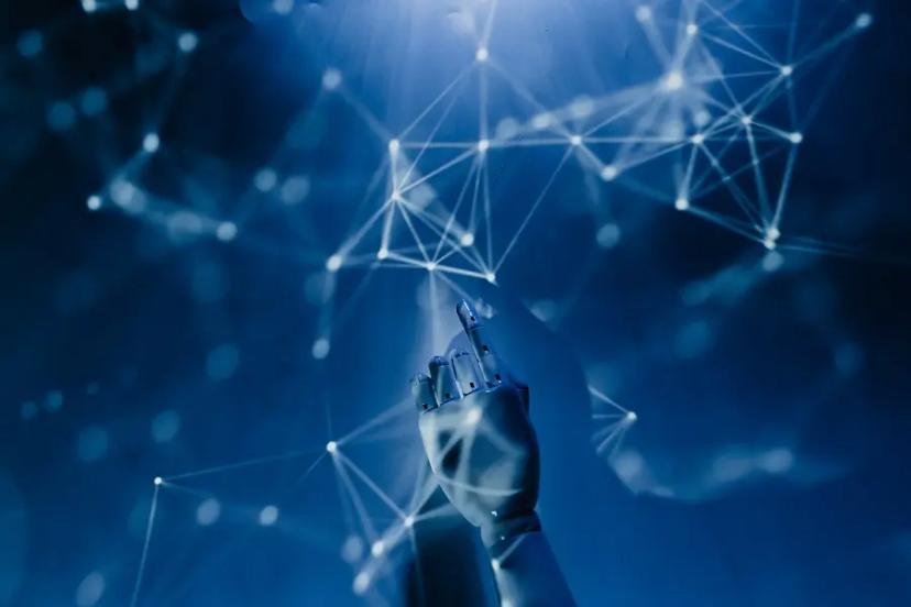 ChatGPT – desafios, riscos e o futuro da inteligência artificial Mão robótica aponta para rede de conexões neurais digitais e pontos de dados luminosos em fundo azul tecnológico.