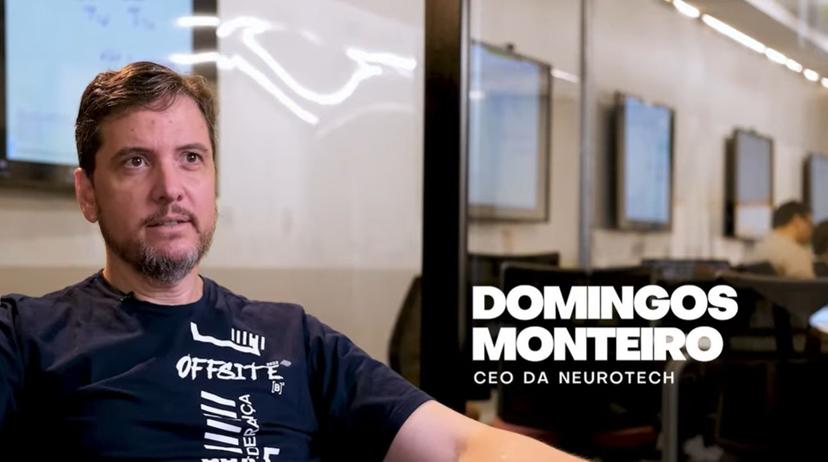 Doutourado profissional conecta mercado e pesquisa aplicada Homem sentado em poltrona durante entrevista em escritório moderno com telas ao fundo sobre doutorado profissional e pesquisa aplicada