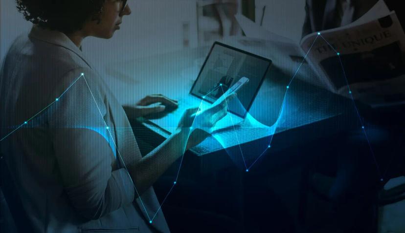 Transformação digital e o impacto das tecnologias no mercado atual Mulher segura smartphone frente a laptop, com sobreposição de gráficos de dados luminosos em tons de azul e ciano.