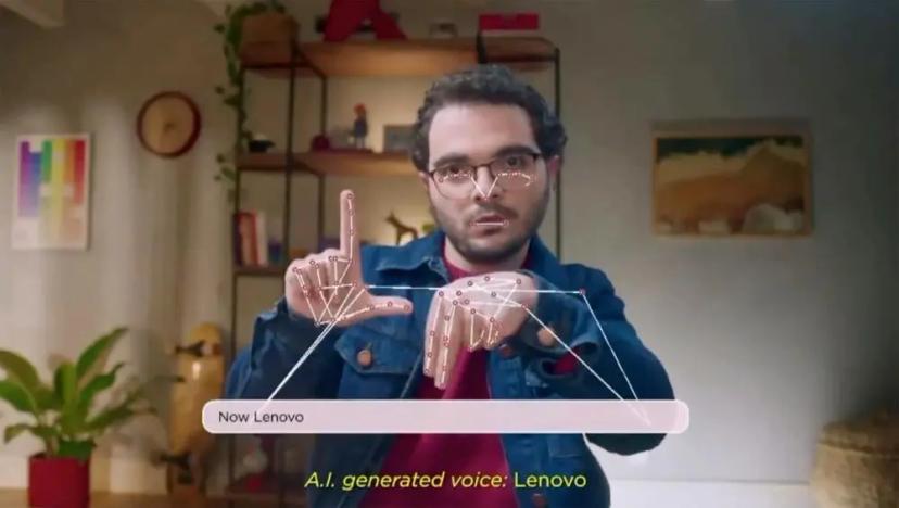 IA para todos – CESAR e Lenovo apresentam acessibilidade no Tech World Homem sinaliza em libras com pontos de mapeamento digital nas mãos e rosto. Texto na tela indica voz gerada por IA.