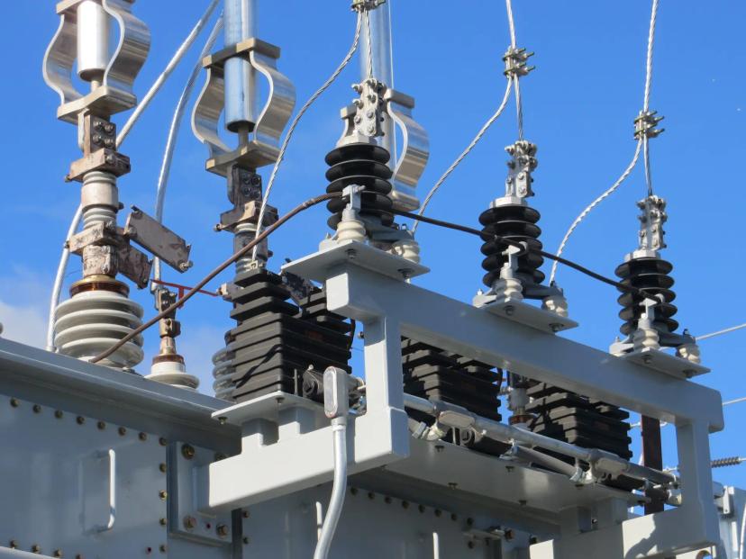 P&D ANEEL e a modernização de subestações com infraestrutura robusta Componentes de alta tensão com isoladores de porcelana e conexões metálicas sob céu azul em subestação de energia elétrica.