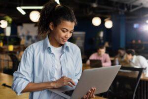 Estudante de tecnologia usando laptop, aprendizado online, educação tecnológica.