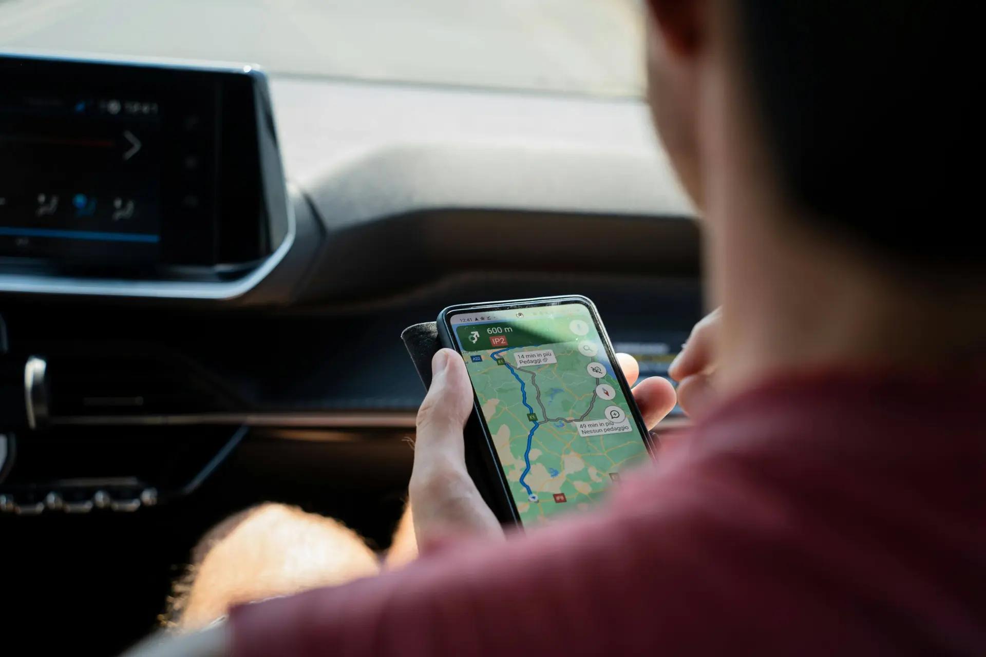 Mobilidade inteligente e conectividade via GPS em tempo real Motorista segura celular com mapa de GPS aberto dentro de carro moderno, mostrando rotas de conectividade e mobilidade inteligente.