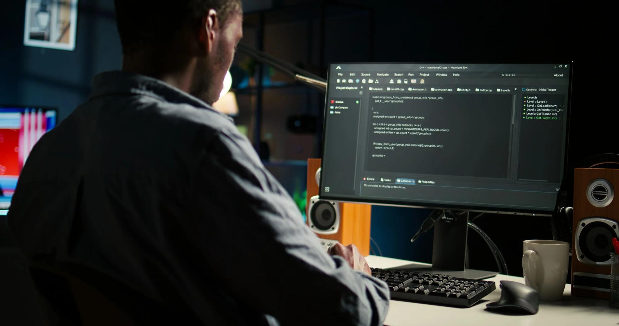 Bradesco e CESAR – Educação corporativa para Cloud e Upskilling Programador negro de costas trabalha com linhas de código em um monitor grande em ambiente de escritório à noite