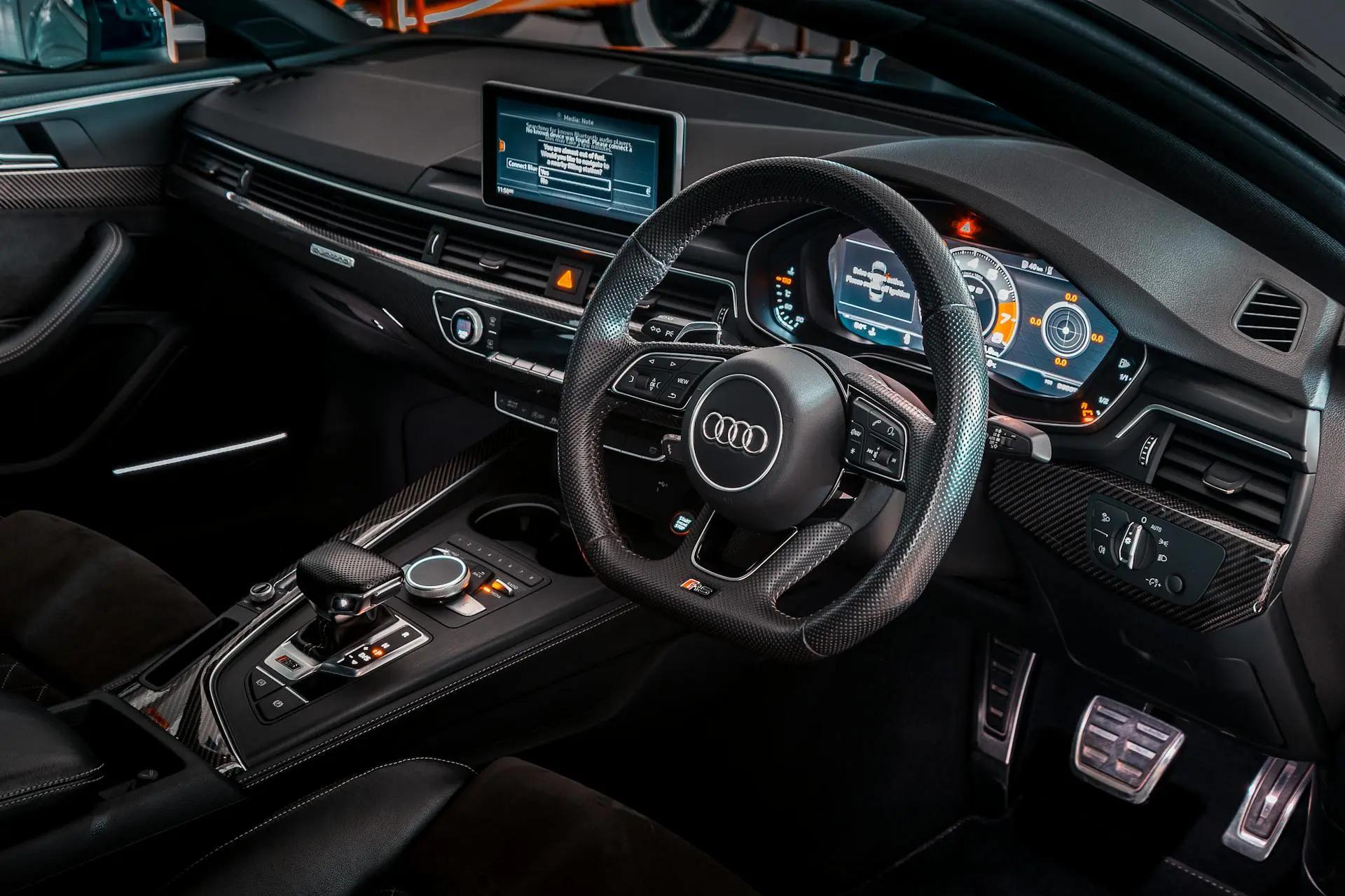 Veículos conectados e a evolução da experiência do usuário no setor Interior moderno de carro luxuoso com painel digital ligado, volante em couro e central multimídia exibindo informações de conectividade.