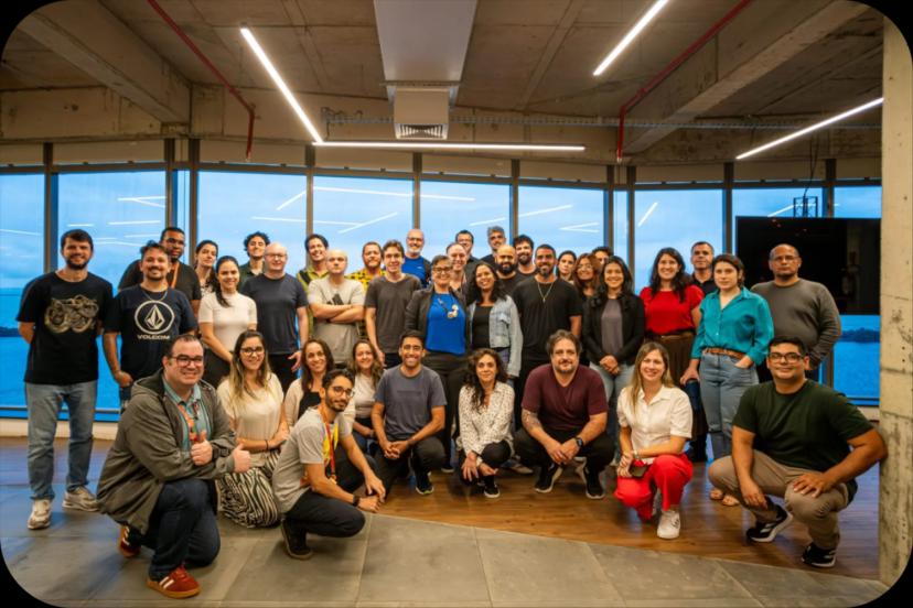 Educação Corporativa no Banco do Brasil – Fortalecendo equipes com o CESAR Grupo de cerca de 30 profissionais sorridentes posa em escritório moderno com grandes janelas de vidro ao fundo.