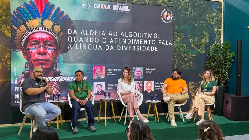 Inclusão Digital e Acessibilidade Financeira para Povos Indígenas Cinco palestrantes sentados em palco com painel ao fundo exibindo foto de indígena e o texto Da Aldeia ao Algoritmo