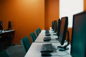 Salas de computadores com mesas e cadeiras