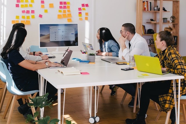 Pessoas em reunião olhando para um monitor