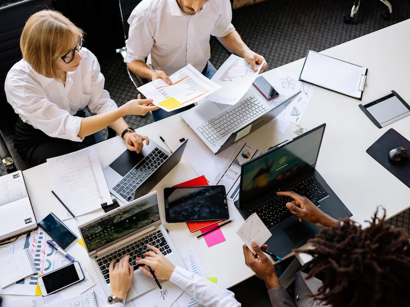 Reunião de equipe com laptops e documentos na mesa