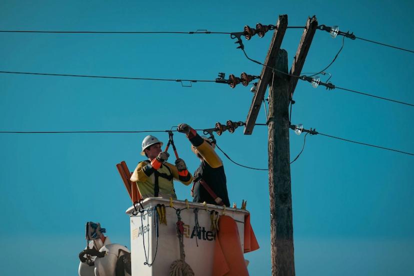 trabalhadores-manutencao-eletrica Trabalhadores em caminhão elevador realizando manutenção elétrica