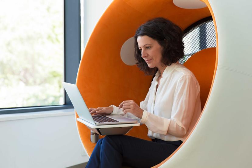 Como liderar uma gestão estratégica no setor financeiro Mulher trabalhando em laptop em cadeira moderna.